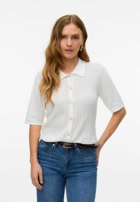 Blusa a maglia bianca a maniche corte con placca di bottoni a scallop e colletto, caratterizzata da un design testurizzato e un tessuto traspirante.