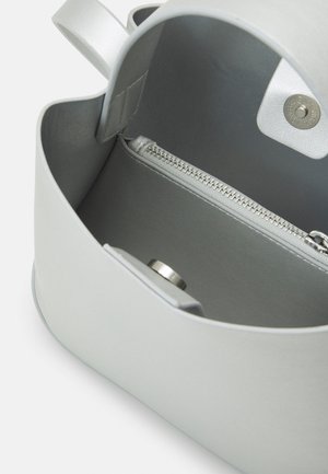 Jasnoszara torebka otwarta, ukazująca wnętrze z kieszenią na zamek i magnetycznym zatrzaskiem na gładkiej skórzanej podszewce.