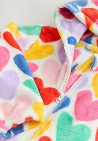 Fleece onesie with a zip closure featuring a white background and multicolored heart patterns in red, pink, yellow, green, and blue.