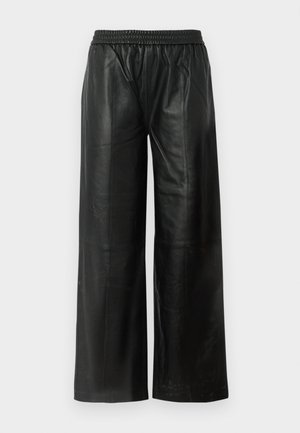 Pantalons larges en cuir noir avec une taille élastique, affichant une texture lisse et un minimalisme au niveau des coutures.
