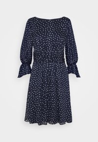 Robe bleu marine à pois blancs, taille froncée, longues manches bouffantes avec poignets à volants, et jupe fluide.