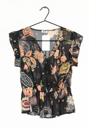 Zwarte doorschijnende blouse met kleurrijke bloem- en paisleypatronen, korte gerimpelde mouwen en een V-hals, hangend aan een zwarte hanger.