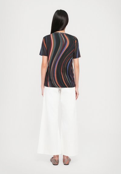T-shirt with swirling multicolored lines on a black background, paired with white wide-leg pants. Smooth fabric, casual fit, short sleeves.
