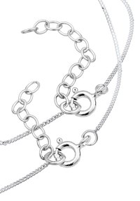 Silbernes Metall Schmuckstück mit Kettengliedern und runden Verschlüssen. Die Ketten variieren in der Dicke und haben ein elegantes, poliertes Finish.