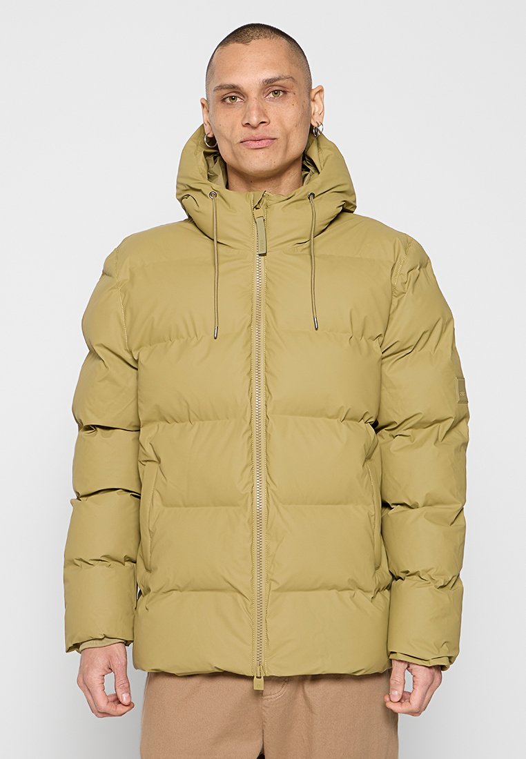 Olijfgroene pufferjack met ritssluiting, verstelbare capuchon en een gevoerd ontwerp. De jack heeft een relaxte pasvorm en elastische manchetten.