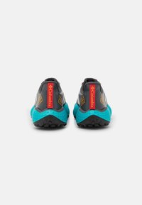Chaussures de randonnée grises et turquoise avec une tige texturée, un contrefort de talon proéminent et un logo Columbia rouge à l'arrière.