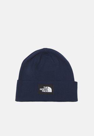 Gorro de punto azul marino con un dobladillo doblado y un parche cuadrado con el logo de "The North Face" en blanco. Textura suave, ajuste ceñido.