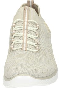 Baskets de sport tricotées beiges avec des lacets élastiques, une tige texturée, des accents de beige clair contrastants et une semelle en caoutchouc blanche.