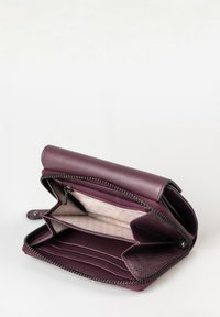 Portafoglio in pelle viola con chiusura a zip, dotato di numerosi scomparti per carte e fodera interna con motivo. Esterno liscio con una leggera texture.