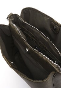 Alyvuogių žalios spalvos pirkinių krepšys su tekstūruotu paviršiumi, keliais užtrauktukais uždarytais skyreliais ir sidabriniais užtrauktukų elementais. Vidus išklotas ir gausus.