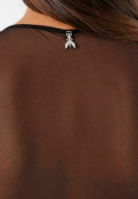 Top negro transparente con un escote redondeado, adornado con un acento de cinta plateada en la parte posterior del cuello. Tejido texturizado con un sutil patrón.