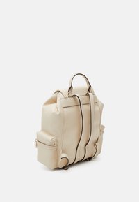 Mochila de cuero beige con diseño estructurado, que cuenta con un asa superior, correas ajustables para los hombros y dos bolsillos laterales con cremallera.