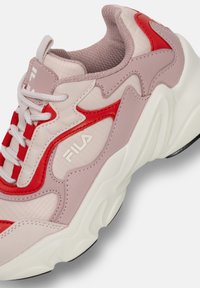 Baskets de sport rouges et roses avec un maillage texturé et des matériaux synthétiques lisses. Présente une semelle intermédiaire blanche et un logo Fila proéminent.