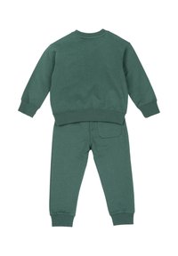 Zielony dres z bawełny, z długimi rękawami i spodniami, z prążkowanymi mankietami i dołem oraz małą tylną kieszonką w spodniach.