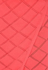 Tessuto lavorato a maglia corallo con un motivo a diamante aperto e cuciture testurizzate. Finitura liscia con una leggera lucentezza, adatto per abbigliamento o accessori.