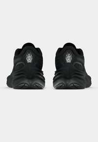 Mustade spordijalatsite paar nähtuna tagantpoolt, kannal leekkäe logo ja tekstureeritud tallamuster.