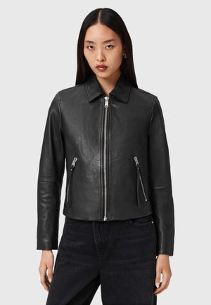 Zwarte leren jas met een kraag, zilveren ritsen aan de voorkant en op de zakken, een nauwsluitend ontwerp, een gladde textuur en lange mouwen.