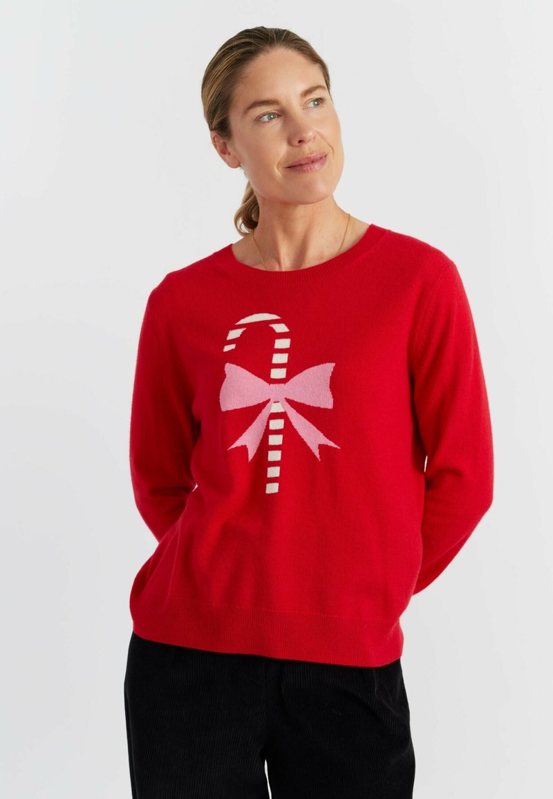 Pull en tricot rouge avec un motif de canne en sucre et de nœud en rose et blanc. Le pull a un col rond et des manches longues.