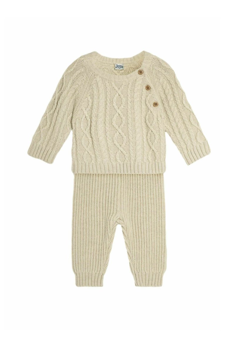 Beige gebreid set bestaande uit een sweater en een broek, met een kabelbreisels ontwerp, drie houten knopen en ribbeltextuur op de manchetten en de zoom.