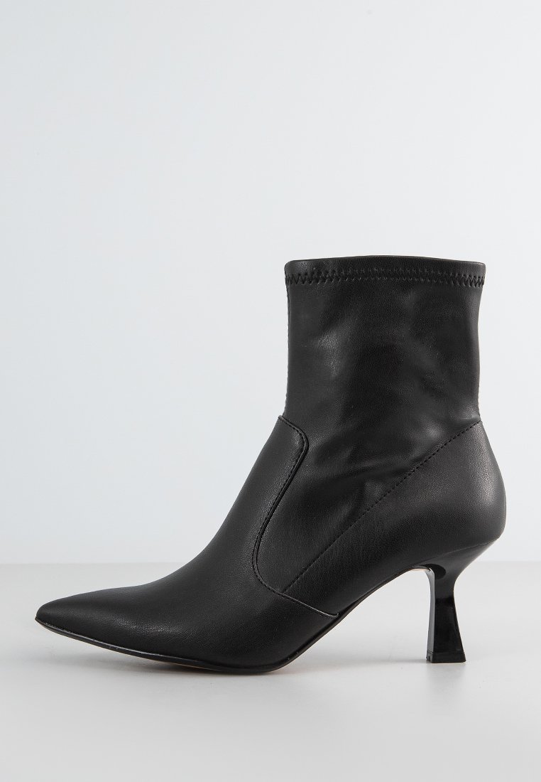 Schwarze Leder-Ankle-Boots mit spitz zulaufender Zehenkappe und einem dünnen, hohen Absatz. Sie verfügen über ein eng anliegendes, glattes Obermaterial und eine gestickte Detail entlang der oberen Kante.
