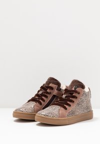 Tenisky do výšky se svrškem z textilu s leopardím potiskem, hnědými semišovými detaily, plochými tkaničkami a chlupatým lemováním límce. Guma v béžové barvě.