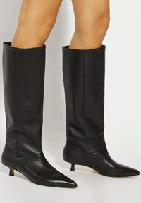 Black leather knee-high boots with a pointed toe, kitten heel, and smooth texture. Fitted design with a sleek appearance.