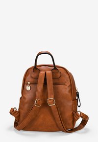 Mochila de imitación de cuero marrón con correas ajustables, bolsillo frontal con cremallera y un encanto metálico redondo. Superficie texturizada y hardware minimalista.