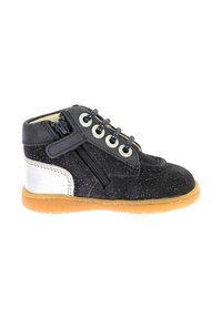 Botín de ante negro y plateado hasta el tobillo con suela de goma marrón, parte frontal con cordones y detalle de cremallera lateral. Presenta una textura moteada.