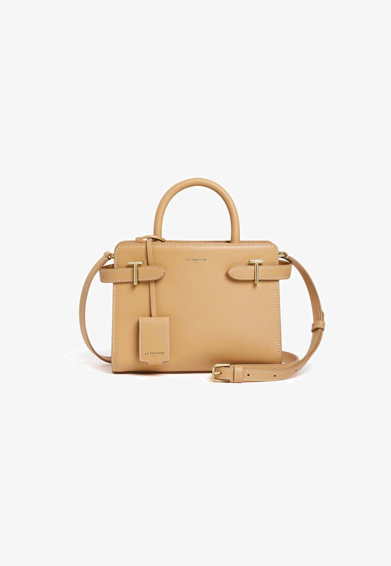 Borsa a mano in pelle color tan con una forma strutturata, doppio manico superiore, tracolla removibile, accessori in metallo dorato e un'etichetta per bagagli.