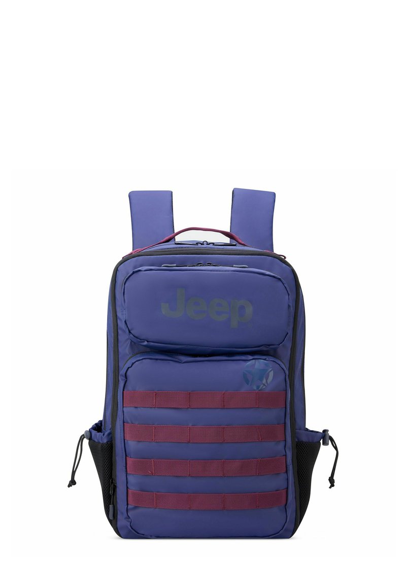 Mochila morada hecha de material duradero que cuenta con un bolsillo frontal, correas horizontales y bolsillos laterales de malla. Logotipo de la marca mostrado de manera destacada.