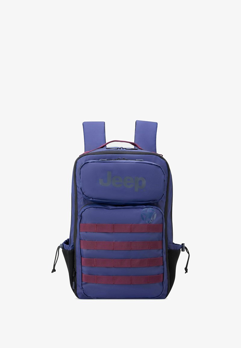 Mochila morada hecha de material duradero que cuenta con un bolsillo frontal, correas horizontales y bolsillos laterales de malla. Logotipo de la marca mostrado de manera destacada.