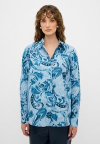 Camicia a maniche lunghe con bottoni in tonalità blu e motivo paisley, tessuto leggero, colletto appuntito e maniche con polsino.