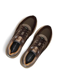 Ein Paar braune und beige Schnürsneaker mit gepolsterten beigen Sohlen und schwarzen Einlegesohlen, die mit "Ambitious" beschriftet sind, von oben betrachtet.