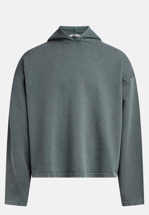 Sudadera corta gris verdosa con una tela texturizada, mangas largas y una capucha triangular. Presenta un dobladillo cosido y una etiqueta en el costado.