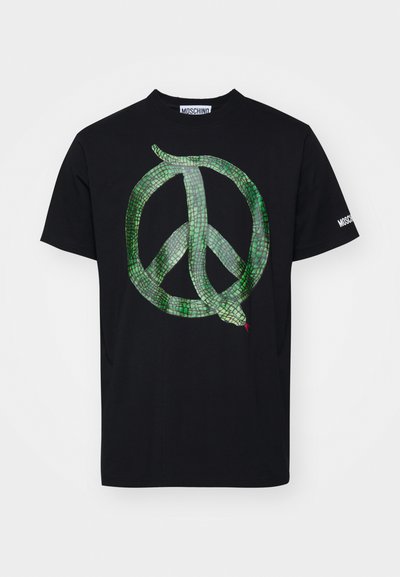T-shirt en coton noir avec un serpent vert intégré dans un graphique de symbole de paix, avec le logo "MOSCHINO" sur la manche en blanc.