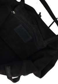 Borsa tote in suede nera che mostra una tasca interna con zip e un'etichetta rettangolare cucita all'interno.