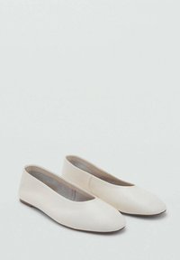 Bailarinas blancas con un tejido suave, punta en forma de almendra, tacón bajo y un diseño suave y minimalista. Sin herrajes visibles ni patrones.
