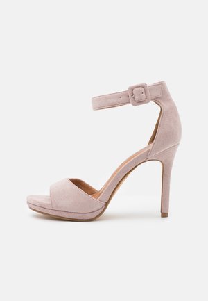 Helle rosa Riemchenpumps aus Wildleder mit offenem Zehenbereich, Knöchelriemen und Schnallenverschluss, seitlich auf weißem Hintergrund abgebildet.