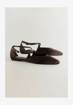 Braune Lederballerinas mit spitzem Zehenbereich, offenen Seiten und einem gekreuzten Riemendesign. Sie haben einen niedrigen Absatz und eine glatte Textur.