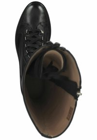 Bota de tobillo de cuero negro con punta redonda, cordones en la parte delantera y detalles en metal plateado. En el interior presenta un forro beige claro.