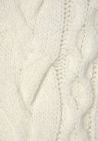 Weißer Strickpullover mit einem strukturierten Muster, dicken Zopfmustern und ineinander flechtenden Abschnitten, der aus einem weichen, kuscheligen Garn gefertigt ist.