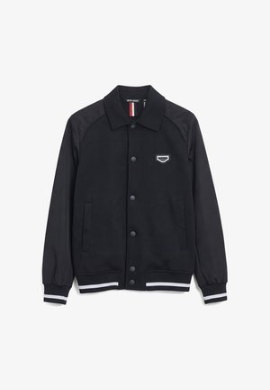 Zwarte jas met knopen, kraag, twee zijzakken, elastische boorden en zoom met witte strepen en een klein logo op de borst.