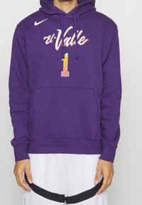 Felpa Nike viola con un grafico colorato "el Valle" e il numero uno sul davanti. Tessuto morbido con tasca a canguro e cappuccio regolabile con cordino.