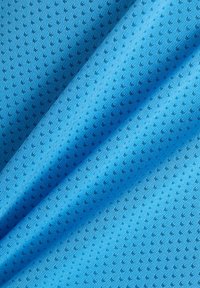 Tissu bleu texturé avec un fin motif de petits points noirs, mettant en avant un matériau léger et respirant, idéal pour les vêtements d'été.