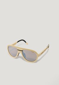 Gafas de sol de plástico amarillo con lentes grises, de forma ovalada y con detalles negros en las patillas. Logo de la marca impreso en un lado.