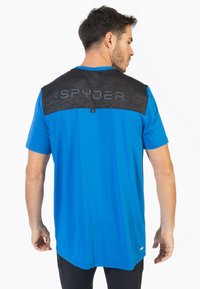 Blå atletisk T-shirt med korte ærmer, en sort mønstret rygdel med ordet "SPYDER" i grå, og en lige søm.
