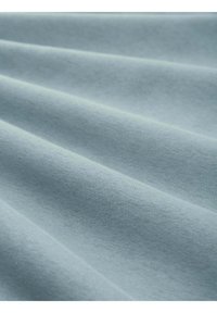 Tessuto di cotone in un morbido blu chiaro, che mostra una texture liscia con pieghe sottili e una superficie pulita e uniforme.