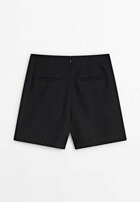 Shorts noirs, design ajusté, présentant deux poches arrière et une fermeture éclair au centre à l'arrière. Texture lisse, sans motifs ni embellissements.