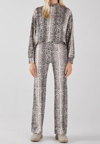 Dopasowany dwuczęściowy zestaw składający się z krótkiego swetra z długim rękawem oraz spodni typu wide-leg z jednolitym wzorem w węża. Miękka, gładka tkanina.