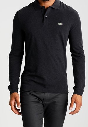 Černá dlouhá polo košile z bavlny, s límečkem a malým zeleným logo krokodýla na hrudi. Hladká textilie.